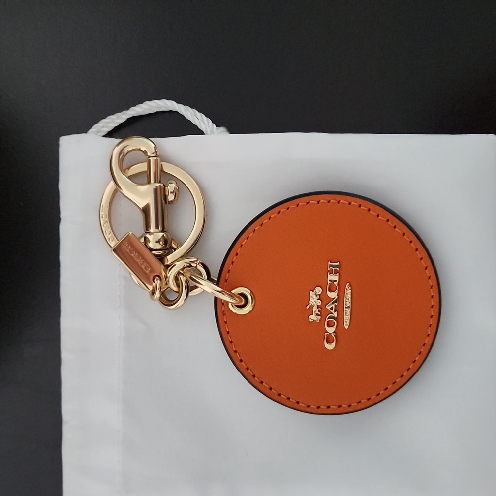 Coach Mirror Bag Charm Keychain includes dust bag.